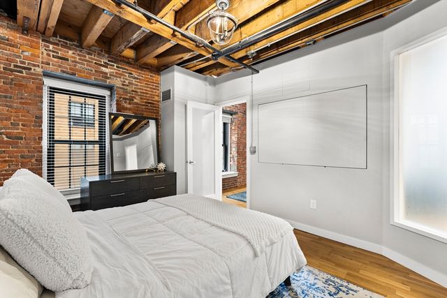 a bedroom with a bed with wooden floor