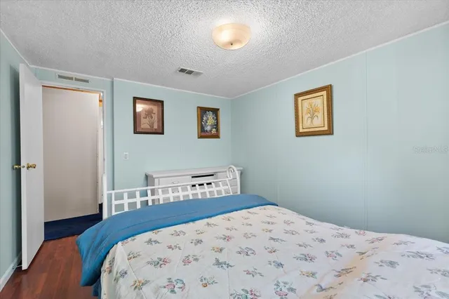 a bedroom with a bed and painting on the wall