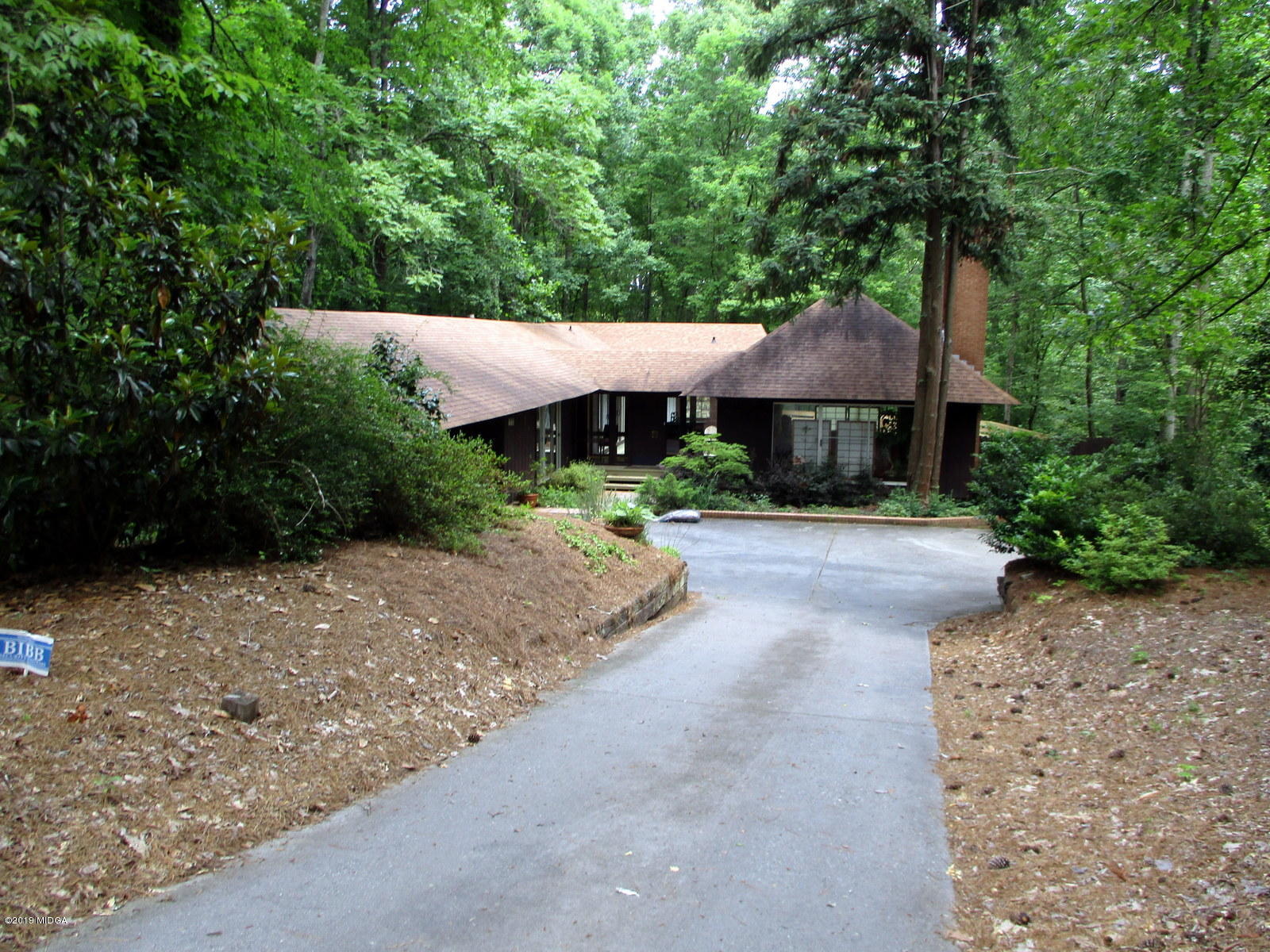 a view of a house with a yard and large tree