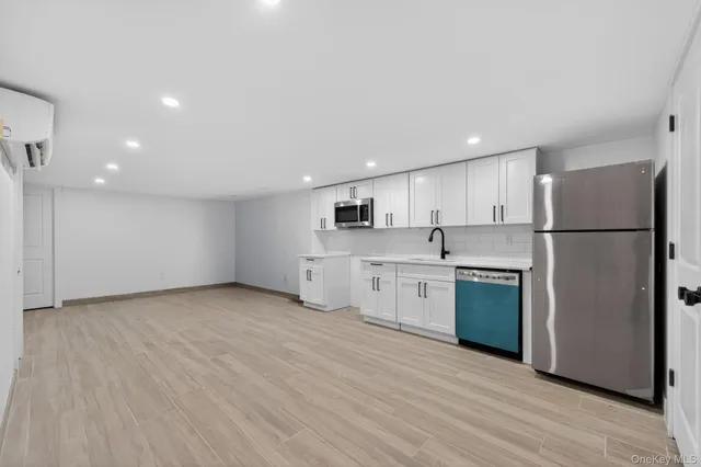 a kitchen with stainless steel appliances granite countertop a refrigerator sink and white cabinets