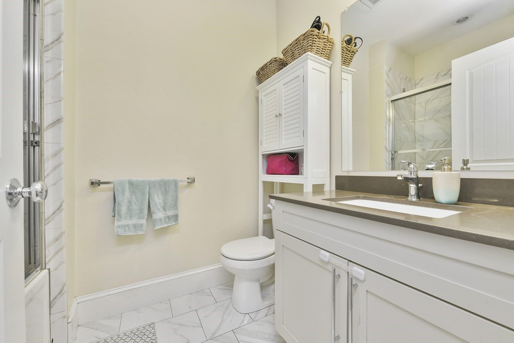 264 Athens Street, Unit 5 Boston, MA 02127 - Photo 14 of 18 a bathroom with a toilet sink and mirror