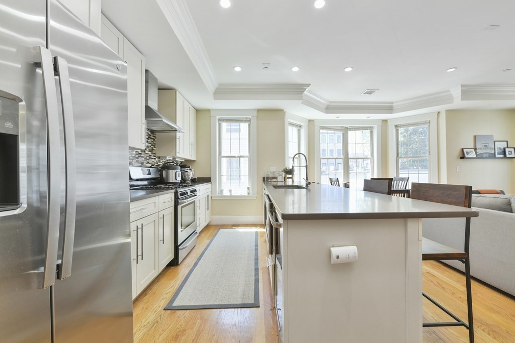 264 Athens Street, Unit 5 Boston, MA 02127 - Photo 2 of 18 a kitchen with stainless steel appliances granite countertop a refrigerator a sink a stove and white cabinets