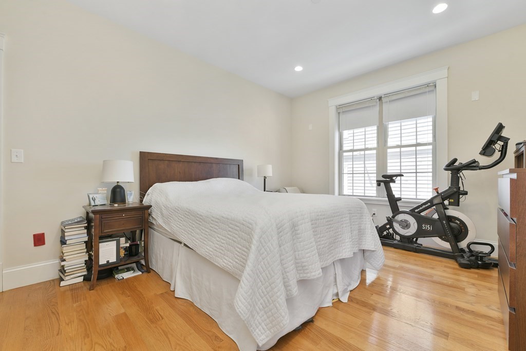 264 Athens Street, Unit 5 Boston, MA 02127 - Photo 9 of 18 a bedroom with a bed and wooden floor