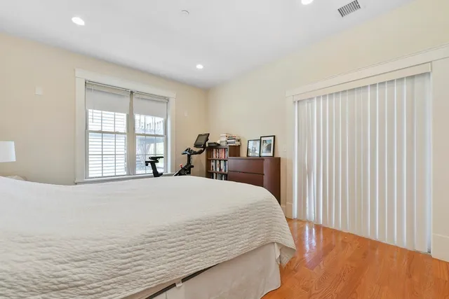 a bed sitting in a spacious bedroom next to a window