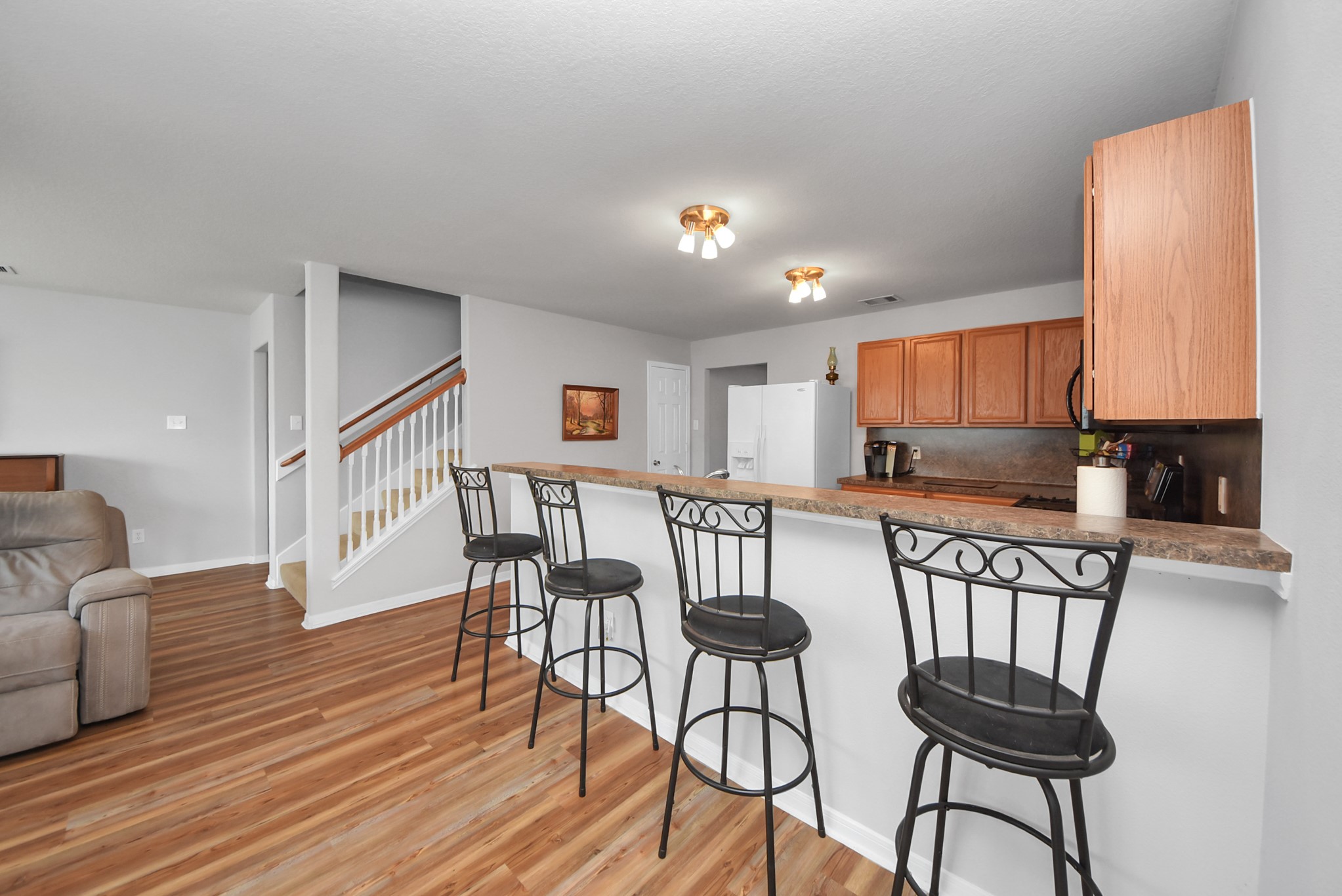16820 Infield Court Conroe, TX 77385 - Photo 12 of 44 a kitchen with stainless steel appliances granite countertop a stove top oven a sink a dining table and chairs with wooden floor