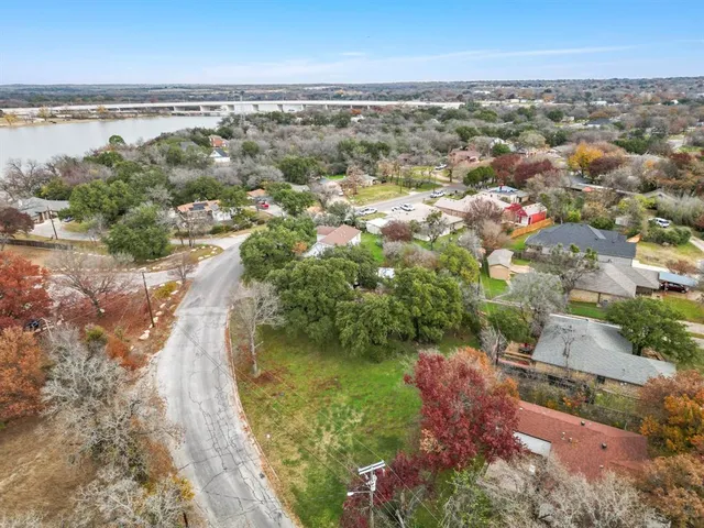 an aerial view of residential houses with outdoor space and lake view