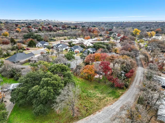 an aerial view of residential houses with outdoor space and trees