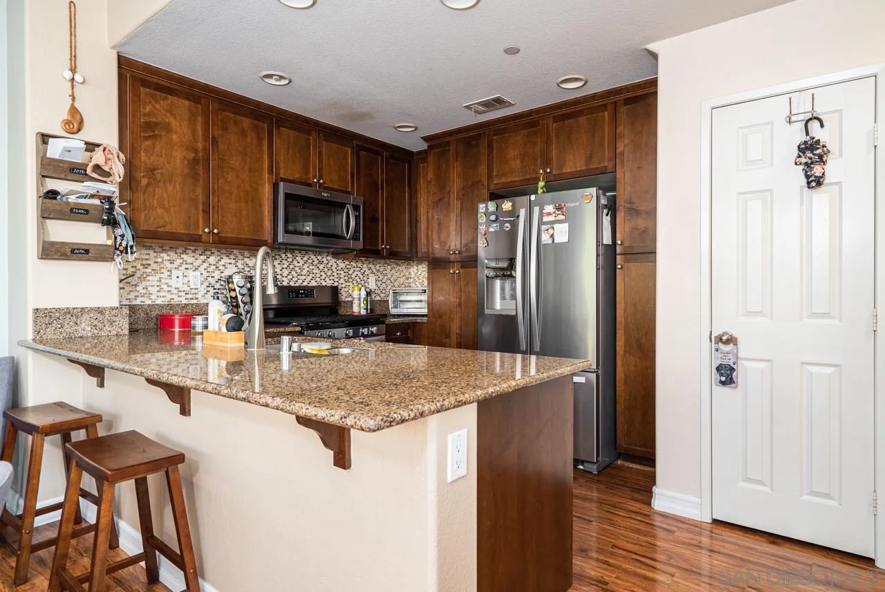 1113 Calabria Street Santee, CA 92071 - Photo 7 of 31 a kitchen with stainless steel appliances granite countertop a refrigerator and a stove top oven