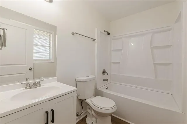 a bathroom with a sink toilet vanity and shower