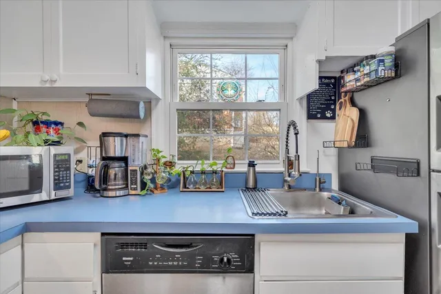 a kitchen with sink a window and cabinets