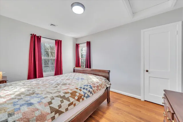 a bedroom with a bed and a wooden floor