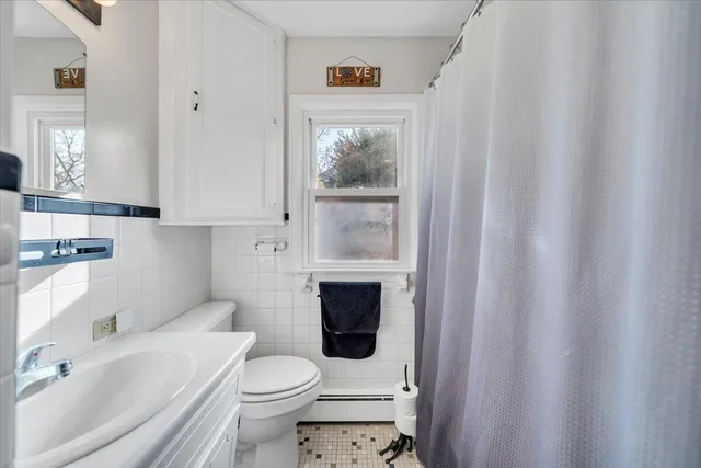 a bathroom with a sink a toilet and shower curtain