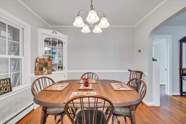 a dining room with furniture wooden floor and a chandelier
