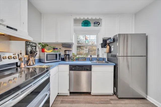 a kitchen with stainless steel appliances granite countertop a refrigerator and a stove