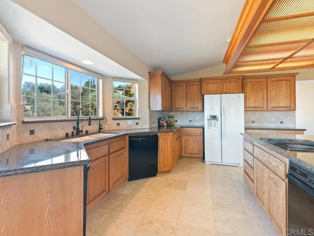 a sink with granite countertop white cabinets and a large mirror
