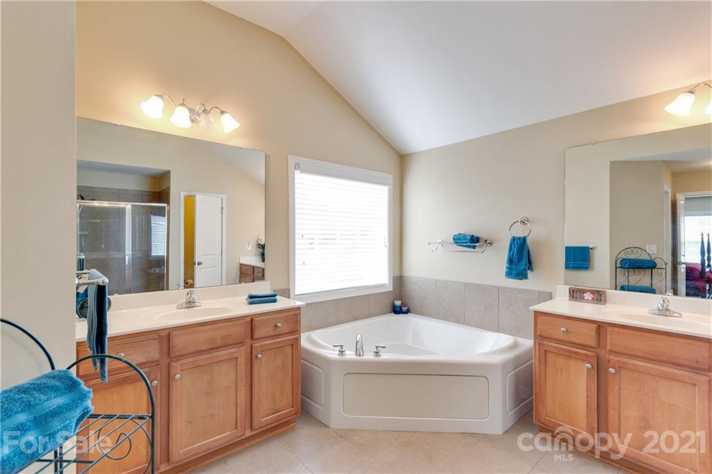 2007 Potomac Road Indian Trail, NC 28079 - Photo 17 of 29 a bathroom with a tub a double vanity sink a window and mirror
