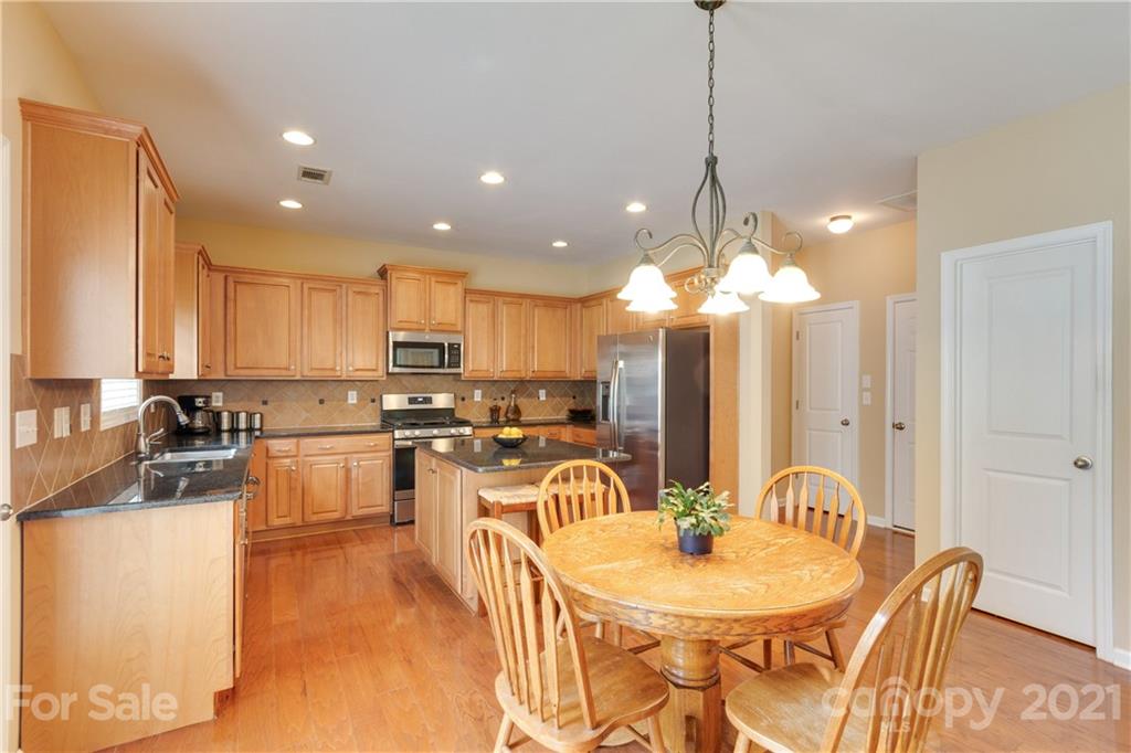 2007 Potomac Road Indian Trail, NC 28079 - Photo 8 of 29 a kitchen with stainless steel appliances granite countertop a sink a stove a dining table and chairs