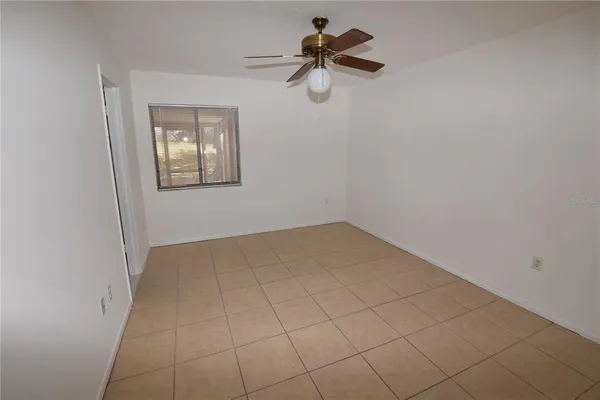 a view of a room with a hanging light and ceiling fan