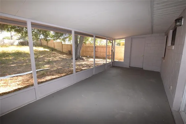 a view of an empty room with wooden floor and a floor to ceiling window