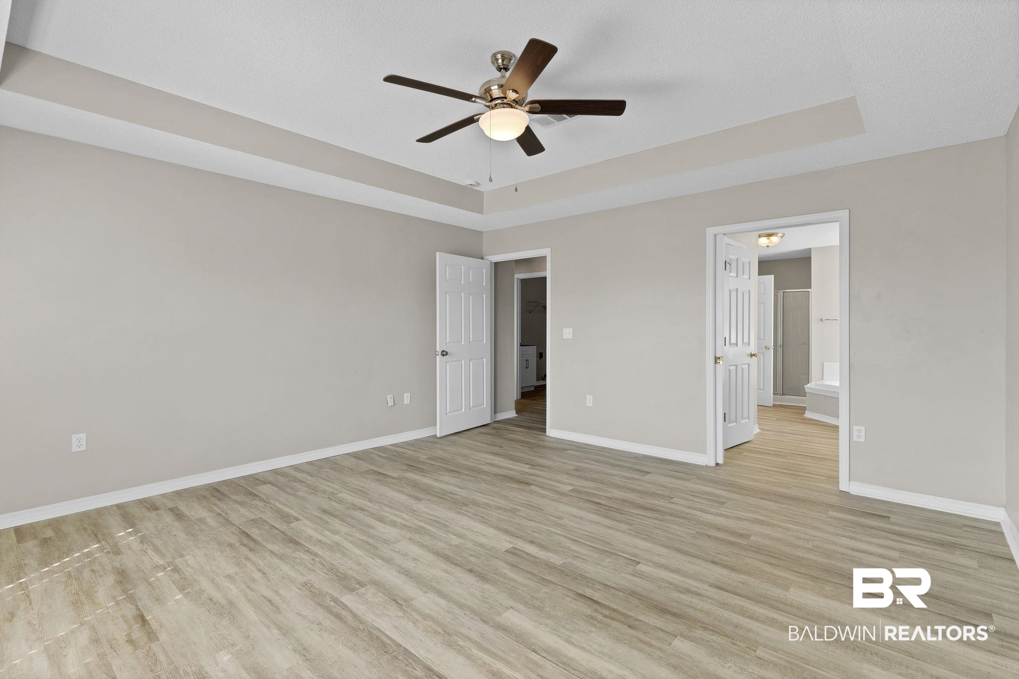 10238 Grove Drive Fairhope, AL 36532 - Photo 14 of 39 Primary bedroom featuring a trey ceiling, fan, and light wood finished floors