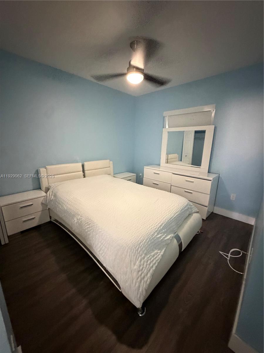 956 Southwest 148th Place Miami, FL 33194 - Photo 12 of 15 a bedroom with a bed and a chandelier