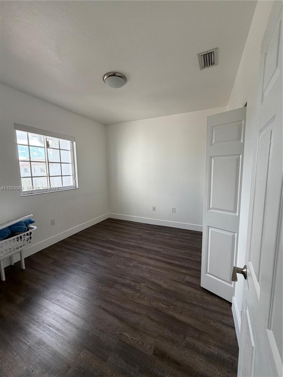 956 Southwest 148th Place Miami, FL 33194 - Photo 13 of 15 an empty room with wooden floor and windows