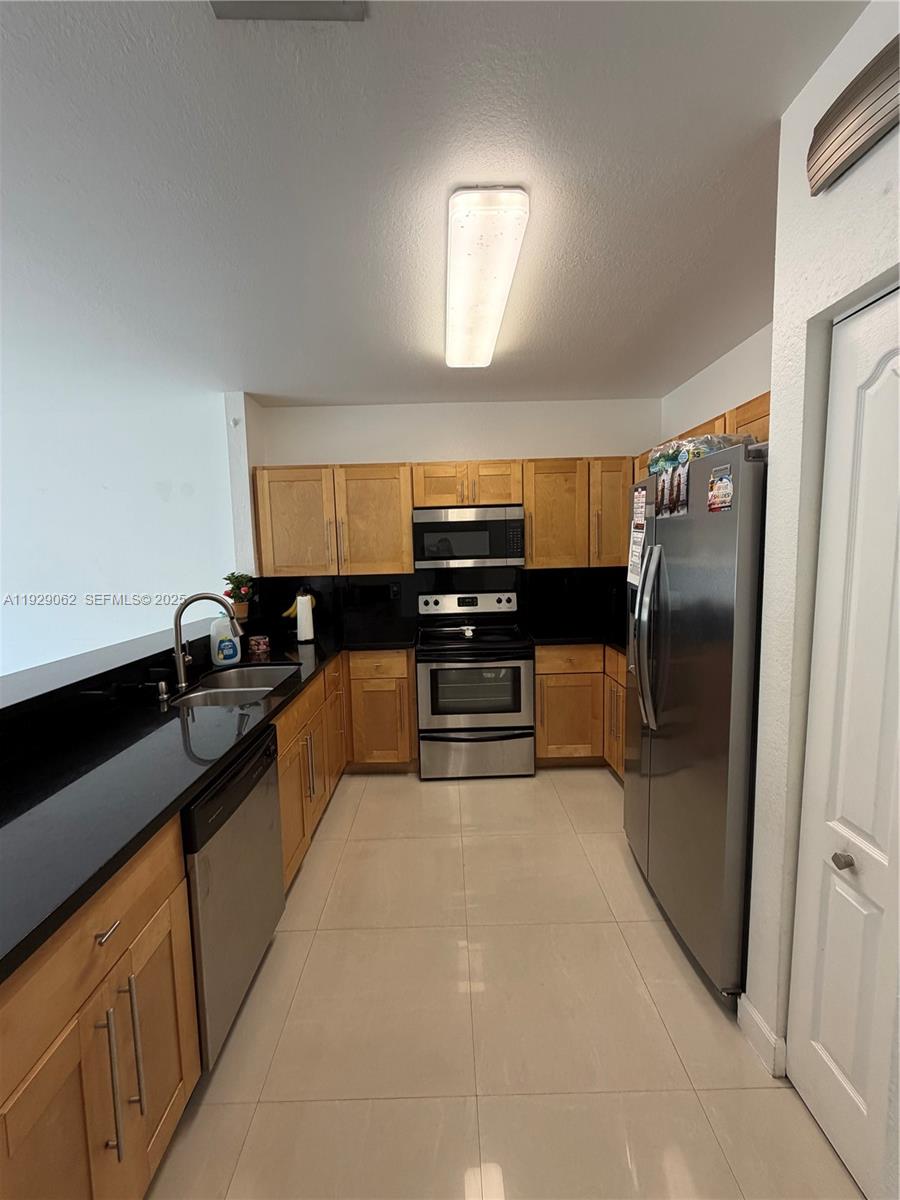 956 Southwest 148th Place Miami, FL 33194 - Photo 5 of 15 a kitchen with stainless steel appliances granite countertop a refrigerator and a sink