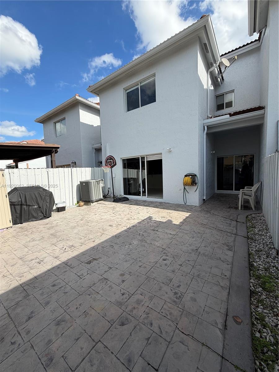 956 Southwest 148th Place Miami, FL 33194 - Photo 8 of 15 a view of a house with a barbeque and large trees