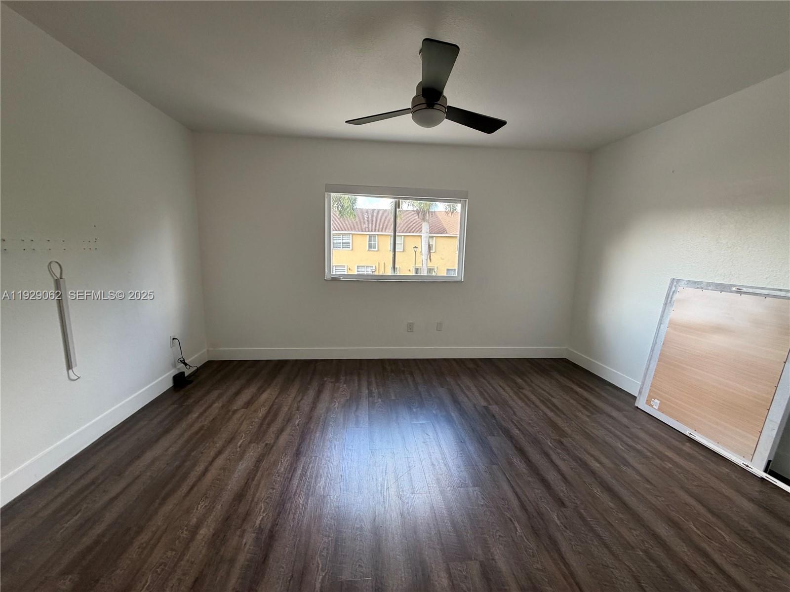 956 Southwest 148th Place Miami, FL 33194 - Photo 9 of 15 a view of an empty room with wooden floor and a window