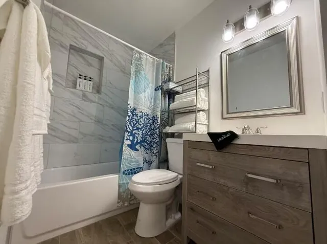 a bathroom with a sink a toilet and shower