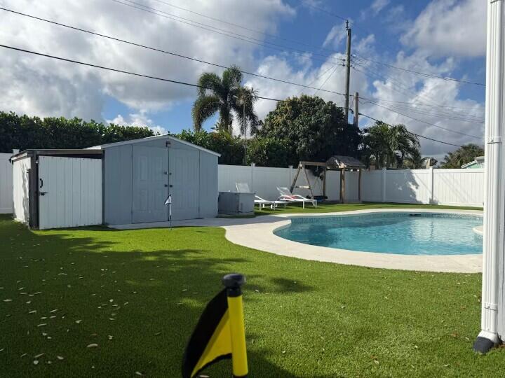 516 East Whitney Drive Jupiter, FL 33458 - Photo 36 of 47 a view of a swimming pool with a yard