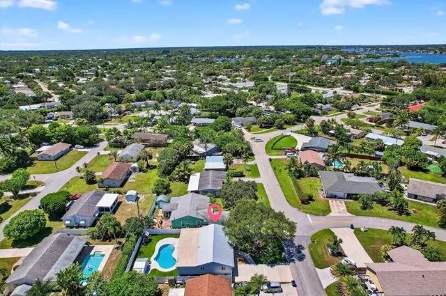 an aerial view of residential houses with outdoor space and trees