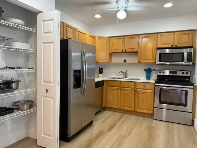 a kitchen with stainless steel appliances granite countertop a refrigerator stove and sink