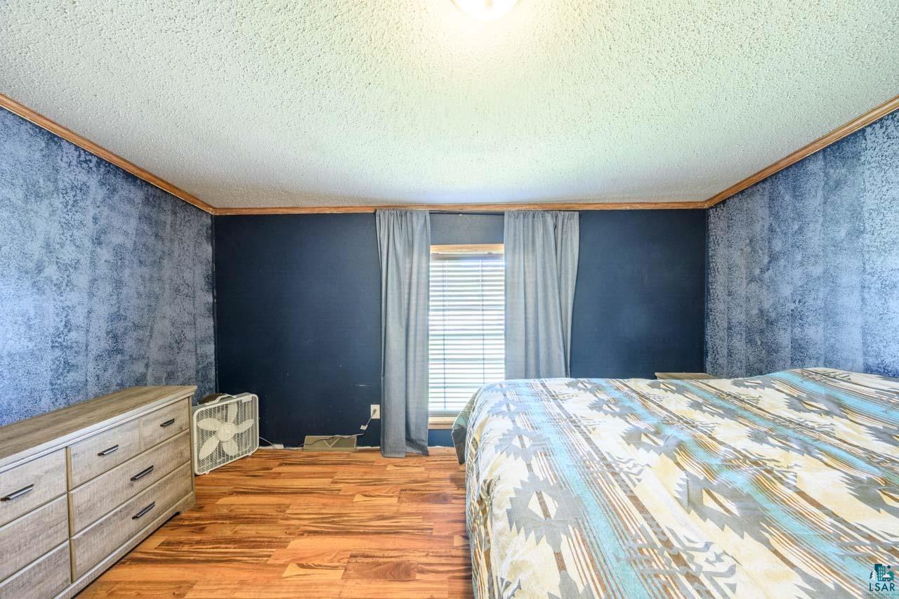3201 Wilderness Road Makinen, MN 55763 - Photo 11 of 44 Wood-finish flooring throughout the room with textured walls and a window featuring horizontal blinds