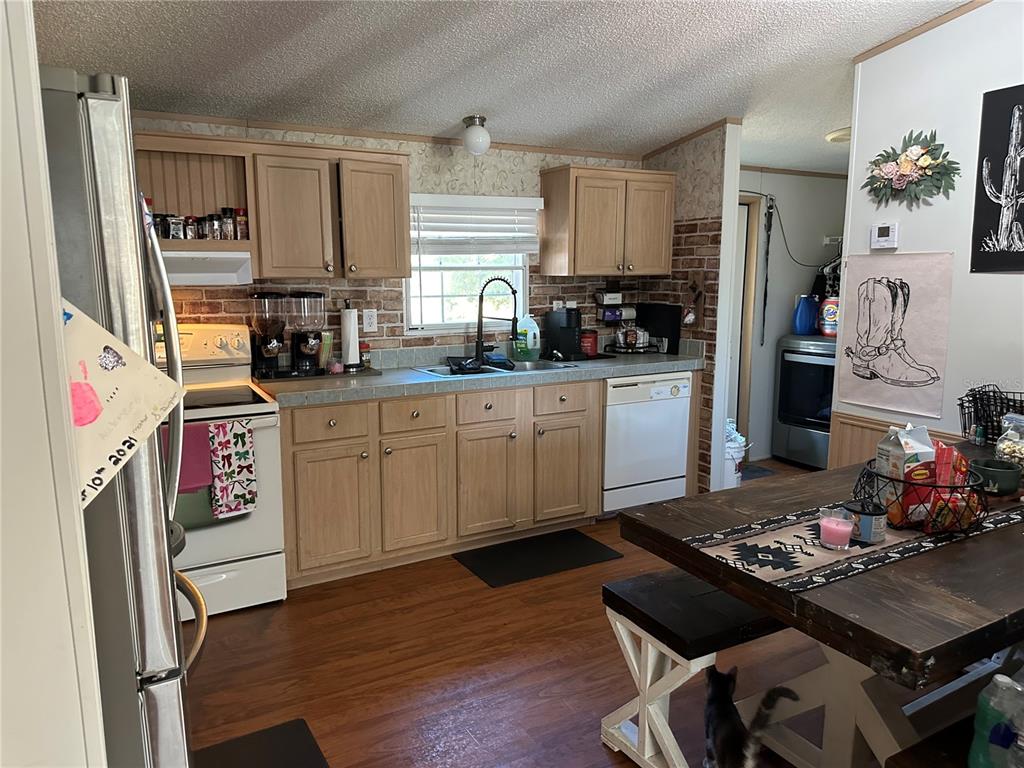 640 Southeast 10th Street Williston, FL 32696 - Photo 6 of 13 a kitchen with a stove a sink wooden floor and a refrigerator