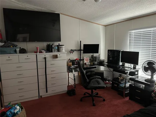 a view of a workspace with furniture and a flat screen tv