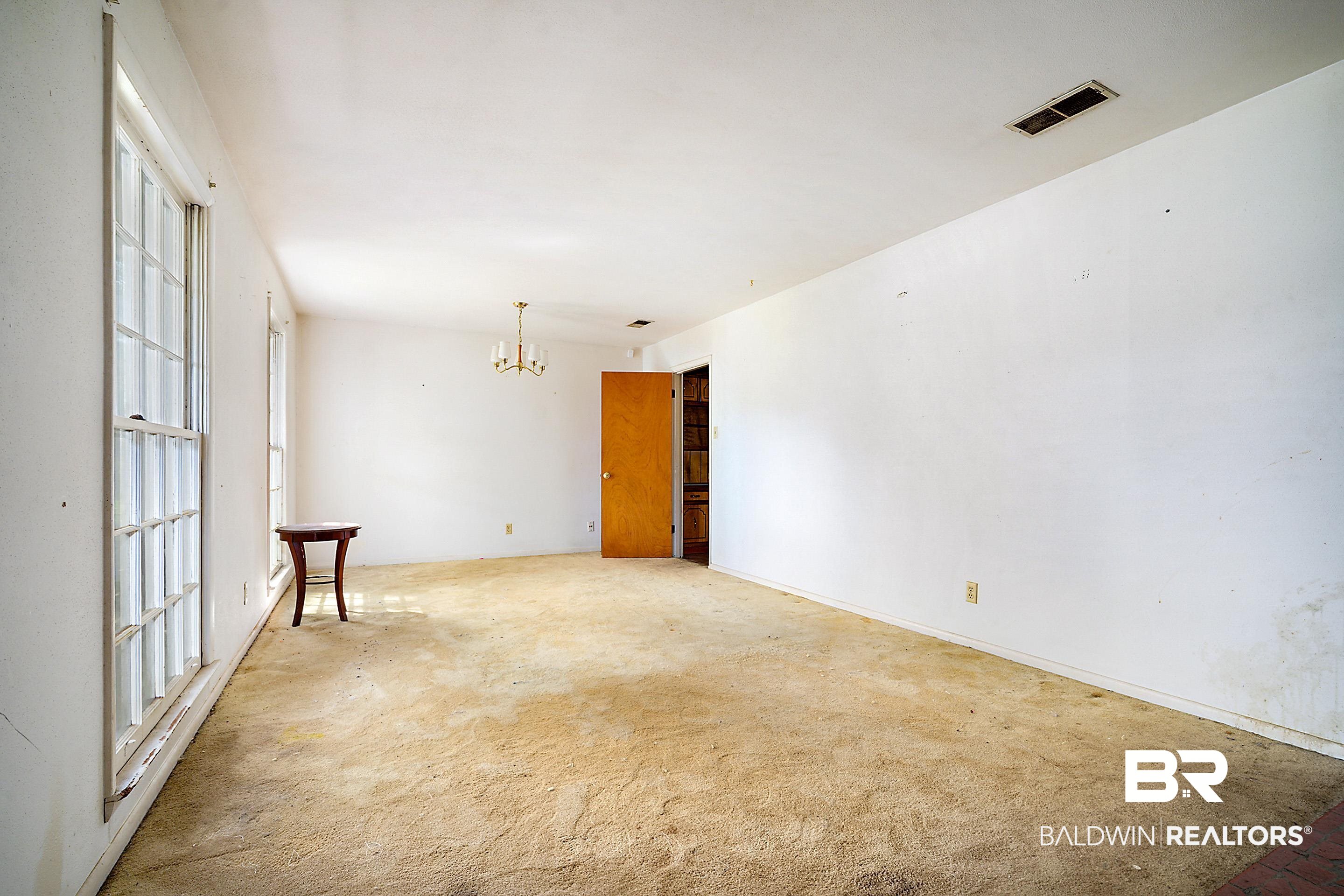 576 Markham Drive Mobile, AL 36609 - Photo 3 of 18 Spare room featuring a chandelier and light colored carpet