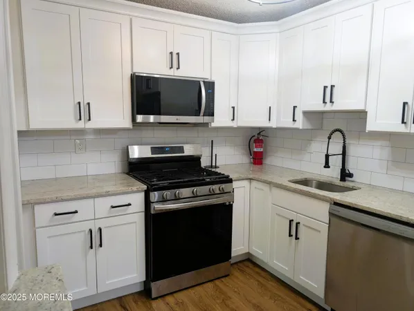 a kitchen with white cabinets and black appliances