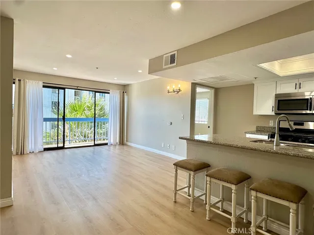 a view of a kitchen with furniture and wooden floor