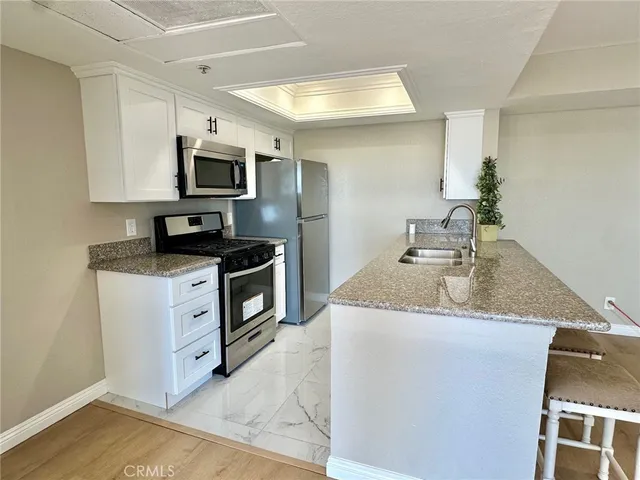 a kitchen with stainless steel appliances granite countertop a sink stove and microwave
