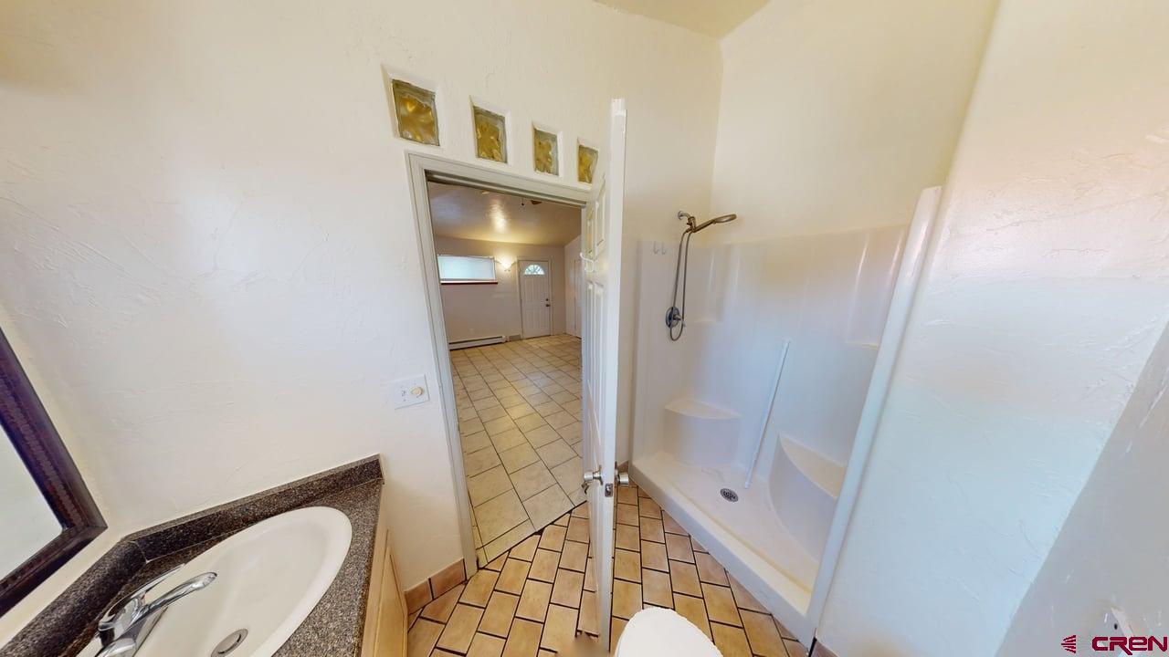 807 13th Street Alamosa, CO 81101 - Photo 21 of 31 a bathroom with a granite countertop sink toilet and shower
