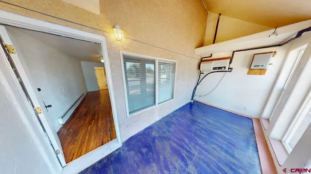 a view of a hallway with wooden floor and stairs