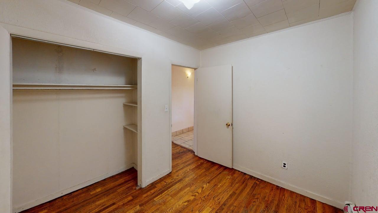 807 13th Street Alamosa, CO 81101 - Photo 8 of 31 a view of an empty room with wooden floor and closet
