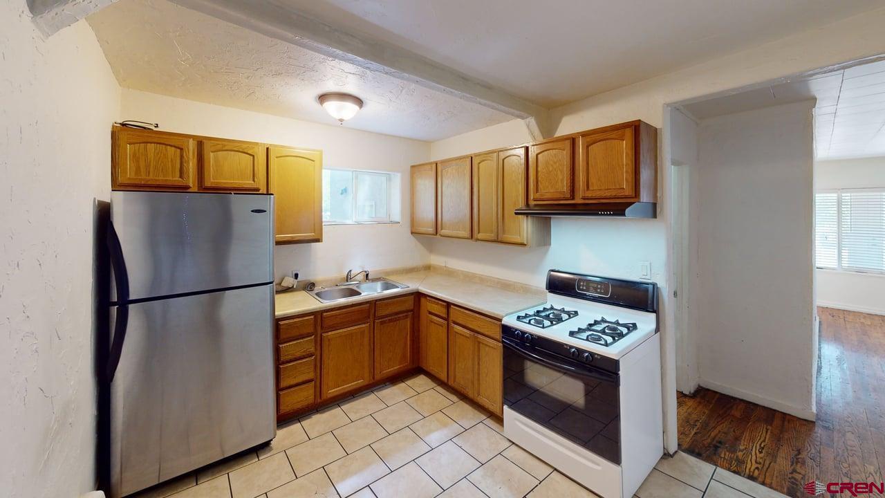 807 13th Street Alamosa, CO 81101 - Photo 10 of 31 a kitchen with stainless steel appliances granite countertop a refrigerator stove a sink and a microwave
