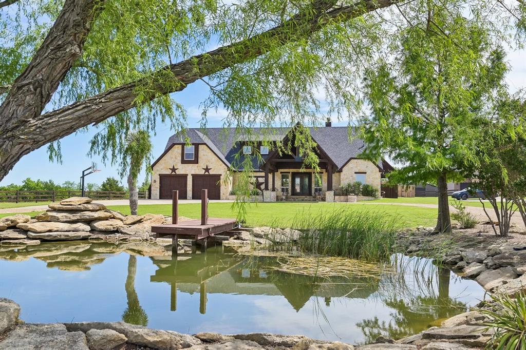 2085 Switzer Road Sanger, TX 76266 - Photo 4 of 39 Manicured pond featuring a wooden dock and natural rock landscaping