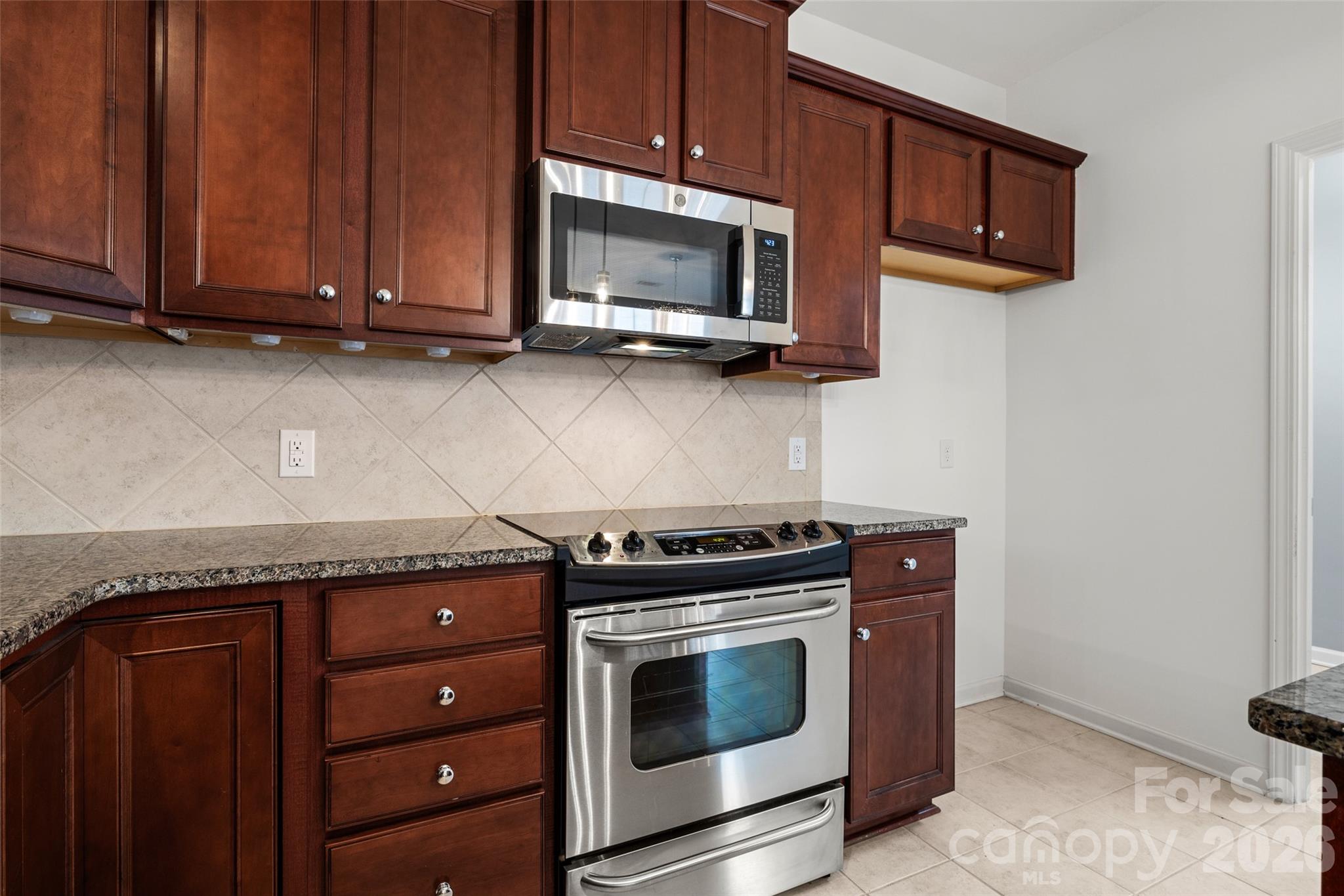 52538 Winchester Street Fort Mill, SC 29707 - Photo 6 of 48 a kitchen with stainless steel appliances granite countertop wooden cabinets and a stove top oven