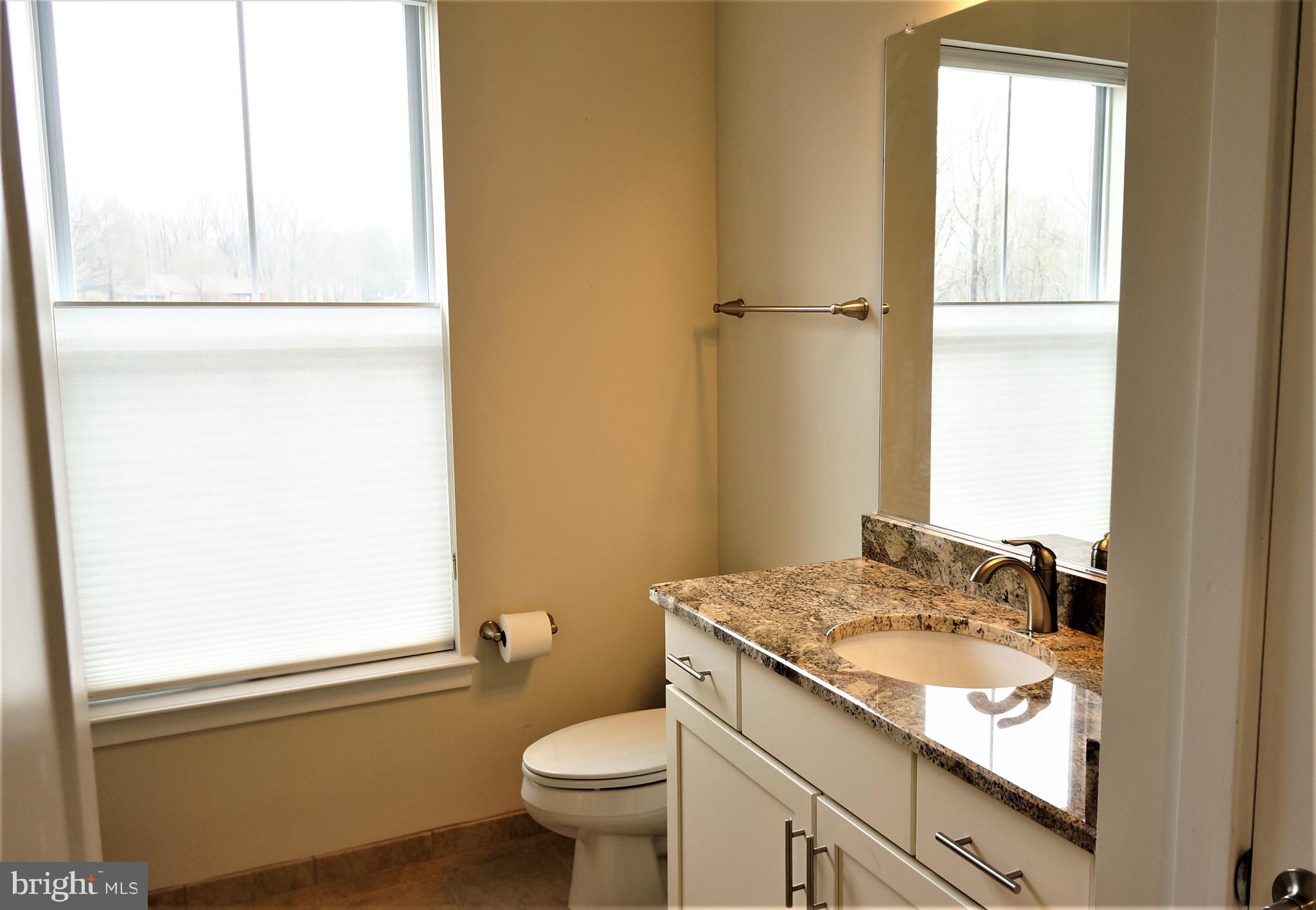 1951 Reston Vly Way, Unit 10 Reston, VA 20191 - Photo 29 of 50 a bathroom with a granite countertop sink toilet and shower