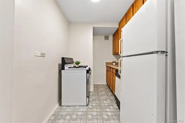 a view of a kitchen with a sink and refrigerator
