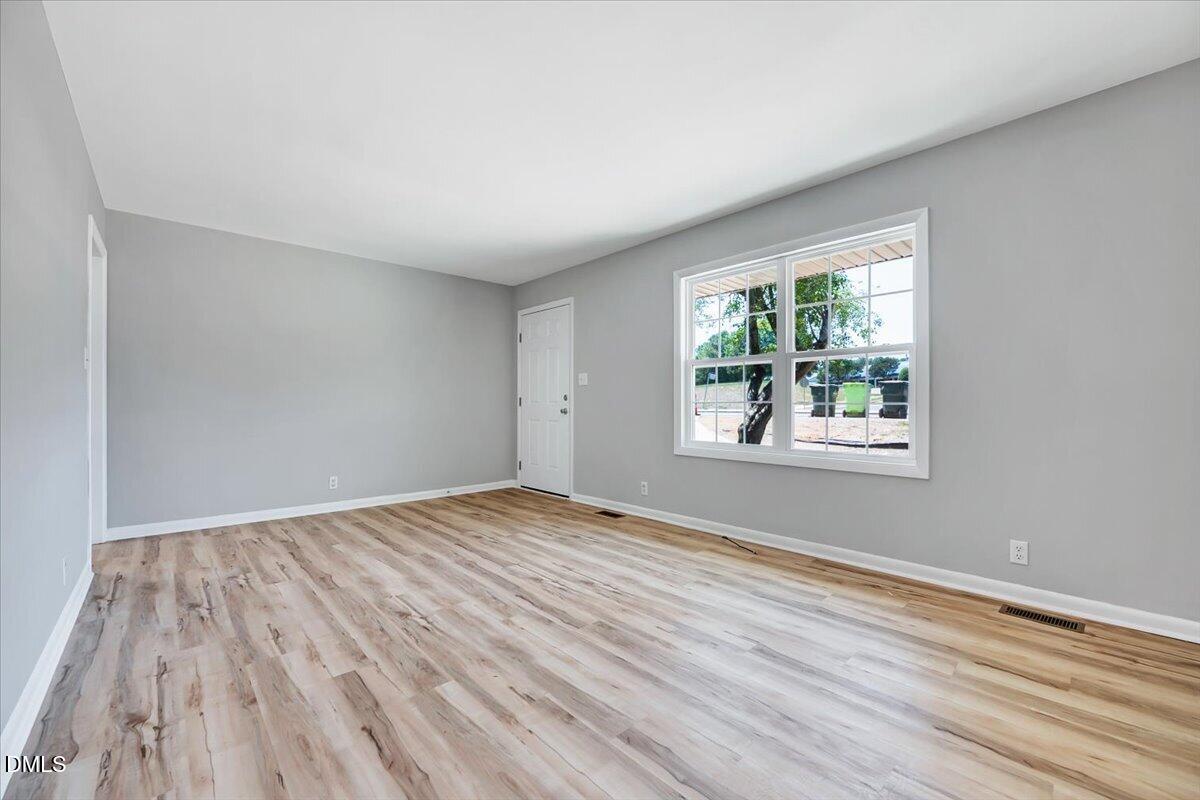 3408 Atlantic Avenue Raleigh, NC 27604 - Photo 6 of 48 a view of an empty room with wooden floor and a window