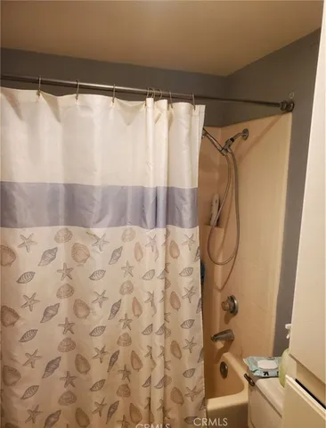 a bathroom with a shower curtain and a window